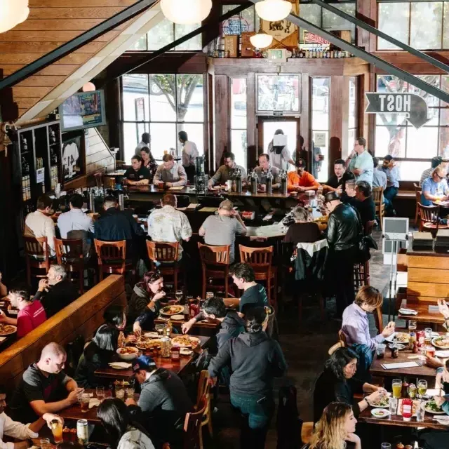 Los clientes comen y beben dentro de la cervecería 21st Amendment en San Francisco.